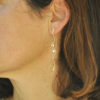 Silhouette gold earrings with pearls on model
