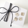 Artisan Custom Minimalist Silver CZ Apparel 4 Buttons are placed on the white gift box tied with black cotton string.