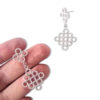 Silver Beaded Quatrefoil Dangle Earrings - on palm of hand for scale