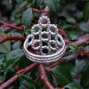 Silver Beaded Quatrefoil Ring - view from the back - against foliage background