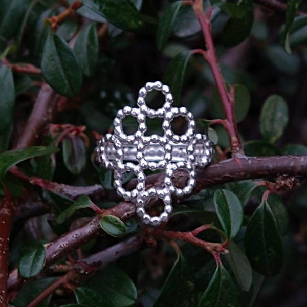 Silver Beaded Quatrefoil Ring - view from the front - against foliage background