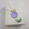 Purple and green disk pendant on top of box