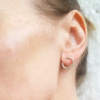 Circle Wire Stud Earrings on an earlobe.