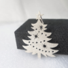 Silver Christmas Tree Hanging Decoration standing next to a black sponge.