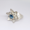 Unique Silver Ring with Blue Topaz on on a white surface.