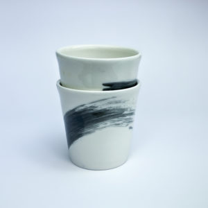 Two porcelain tumblers stacke dinside each other