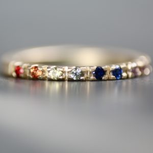 Close up of rainbow sapphire pavé ring.